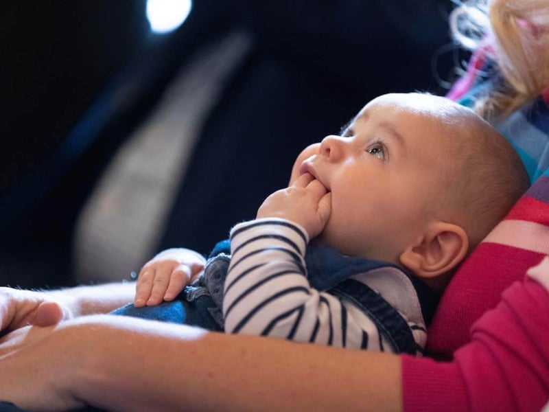 baby with fingers in their mouth